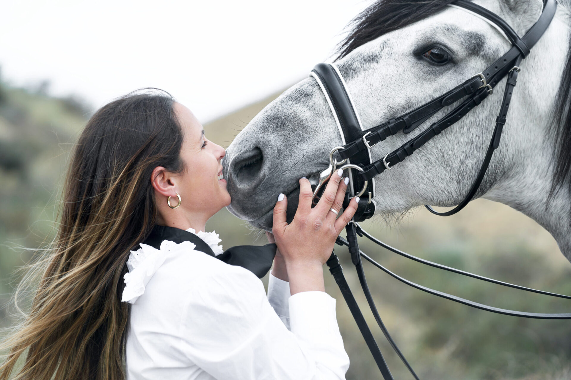 Woman gives horse a kiss